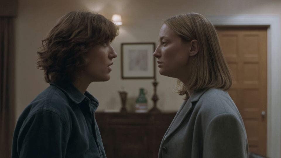 Two people in a room, with detailed faces, subtle expressions and natural lighting.